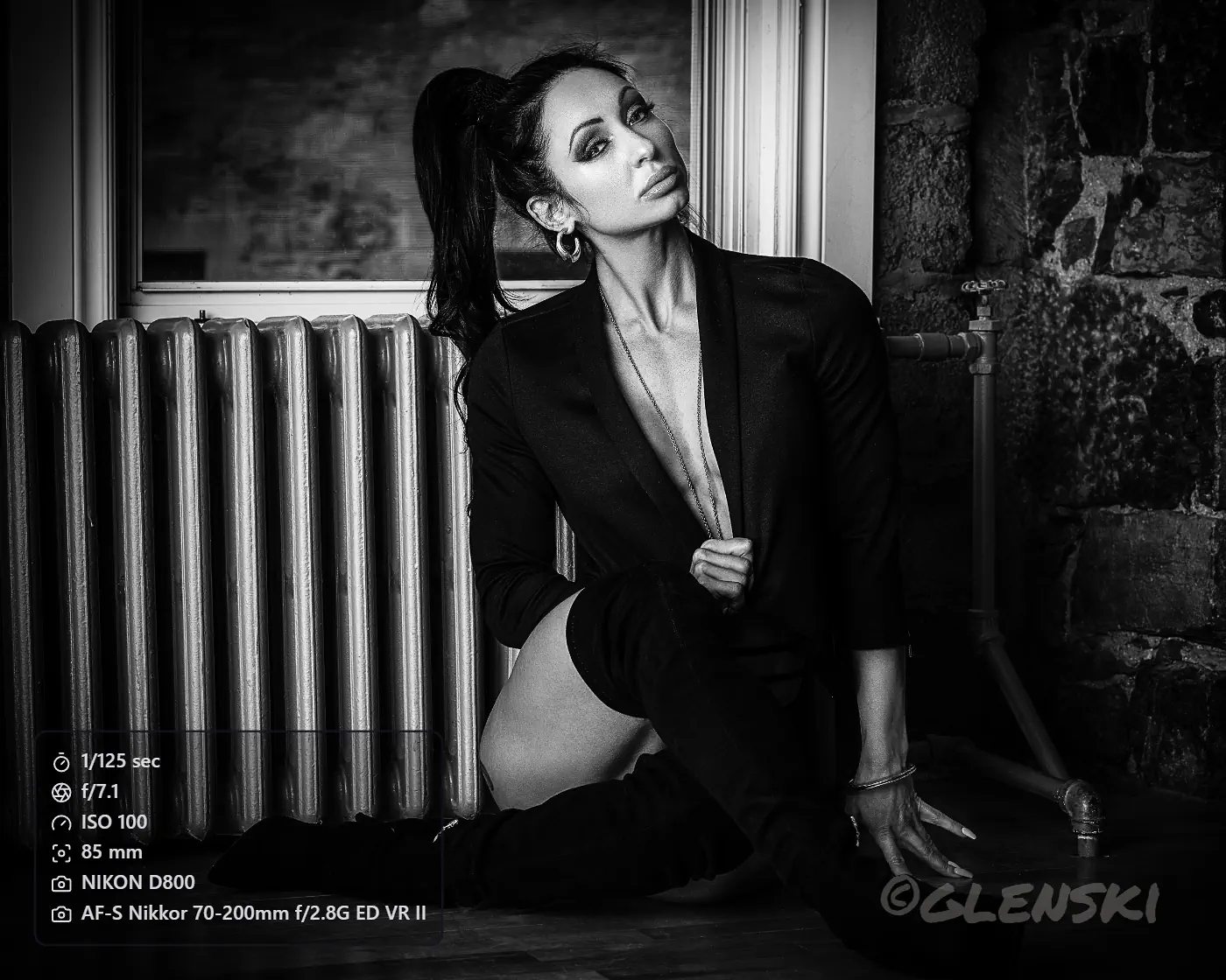 Editorial black and white photograph with a Camera Info overlay panel showing shutter speed, aperture, ISO, focal length, camera body, and lens, plus a signature watermark